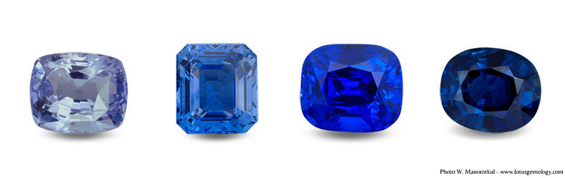 Four sapphires displayed side by side, each showing varying shades of blue under different lighting conditions—from a pale violet-blue on the far left to an intense royal blue and a deep inky blue on the right.
