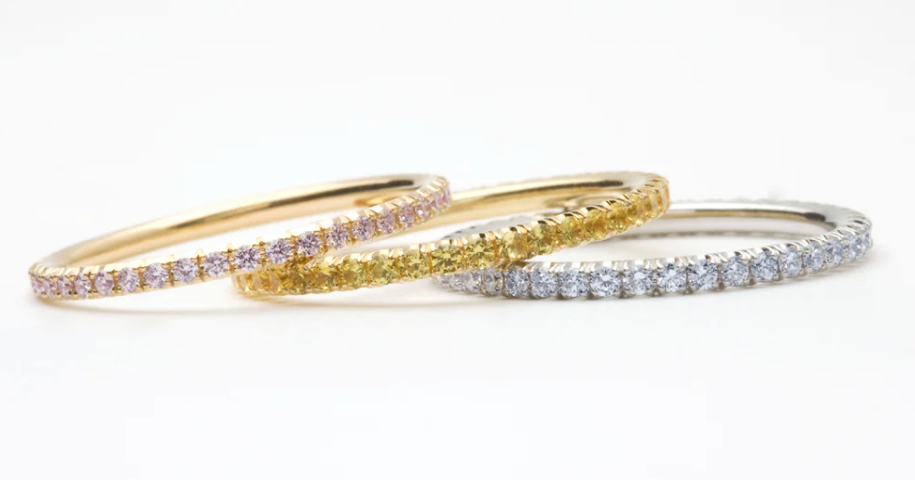 Eternity rings with Pink, Yellow, and Blue diamonds.