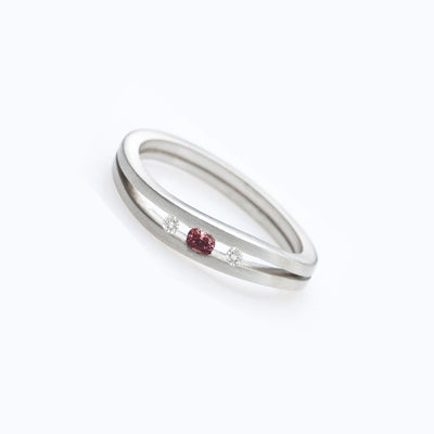 Three-stone engagement ring set with a burgundy diamond